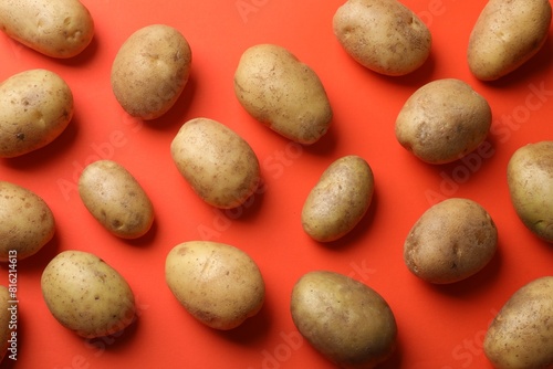 Many fresh potatoes on red background, flat lay