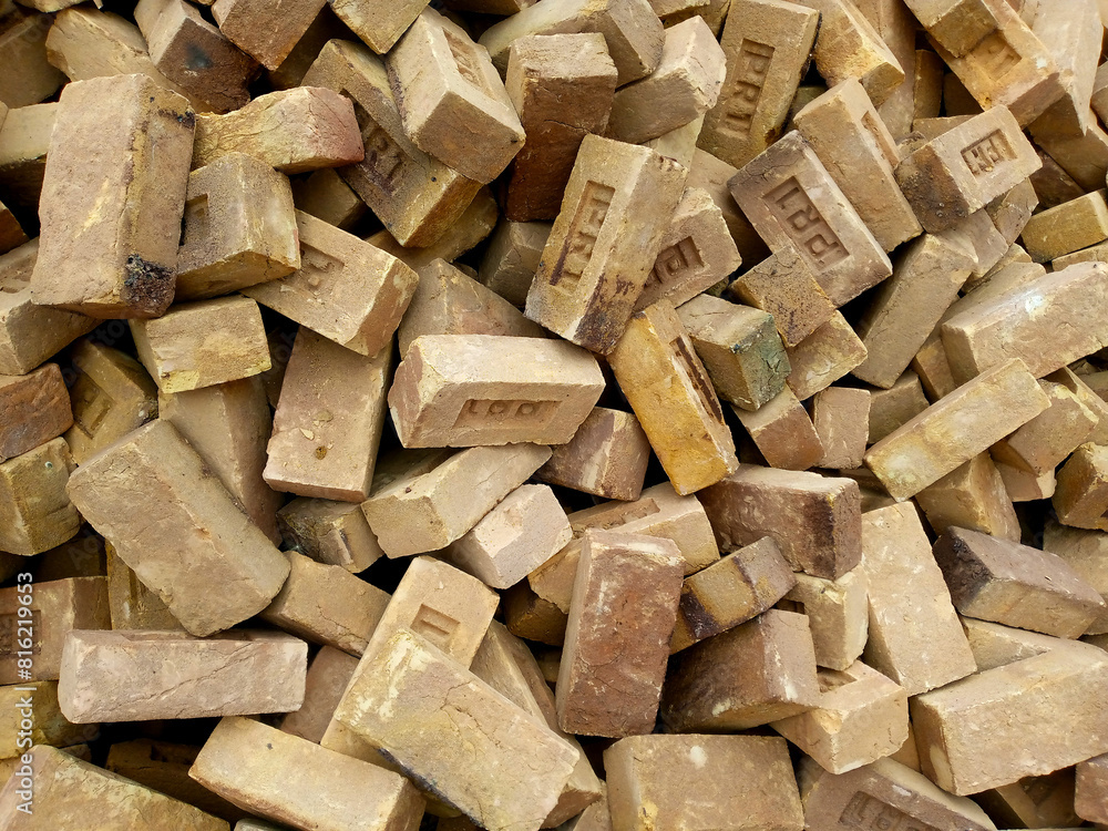 stack of bricks on the ground random irregular one above another collected and stocked for construction