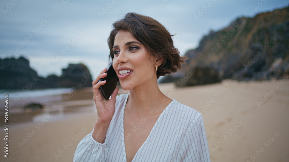 Smiling woman calling beach on cloudy day closeup. Relaxed girl talk smartphone Smiling woman calling beach on cloudy day closeup. Relaxed girl talk smartphone