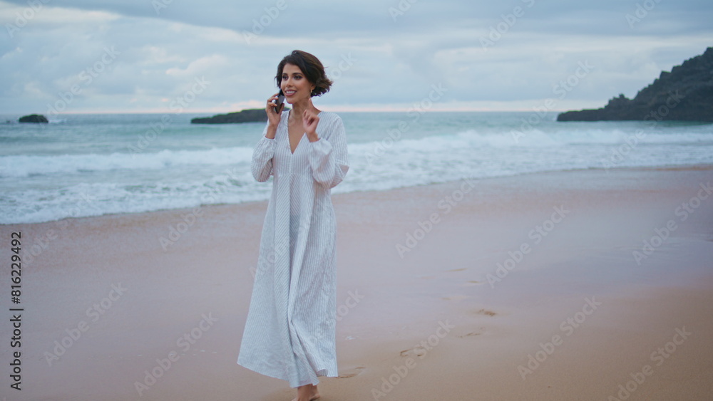 Carefree girl speaking smartphone on beautiful ocean beach. Smiling lady calling Carefree girl speaking smartphone on beautiful ocean beach. Smiling lady calling