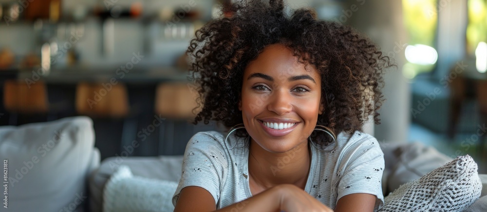 Fototapeta premium Young black woman smiling on couch