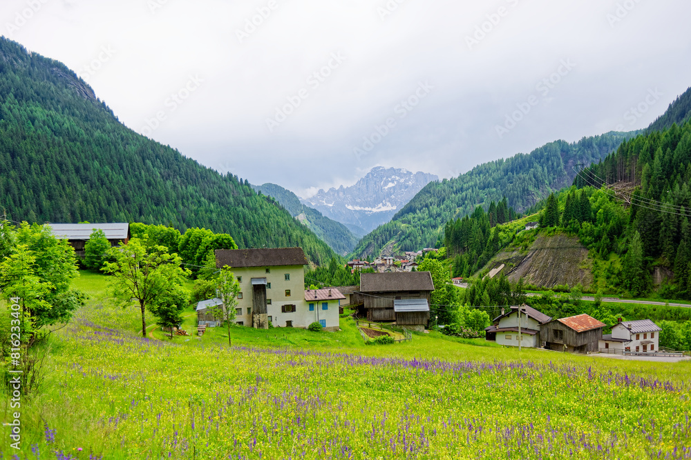 Small rural village nestled in the Dolomite Mountains Italy.Green morning scene of countryside in Swiss Alps, Bernese italian in the canton of Bern, Switzerland, Europe. Alpine mountain pasture Small rural village nestled in the Dolomite Mountains Italy.Green morning scene of countryside in Swiss Alps, Bernese italian in the canton of Bern, Switzerland, Europe. Alpine mountain pasture