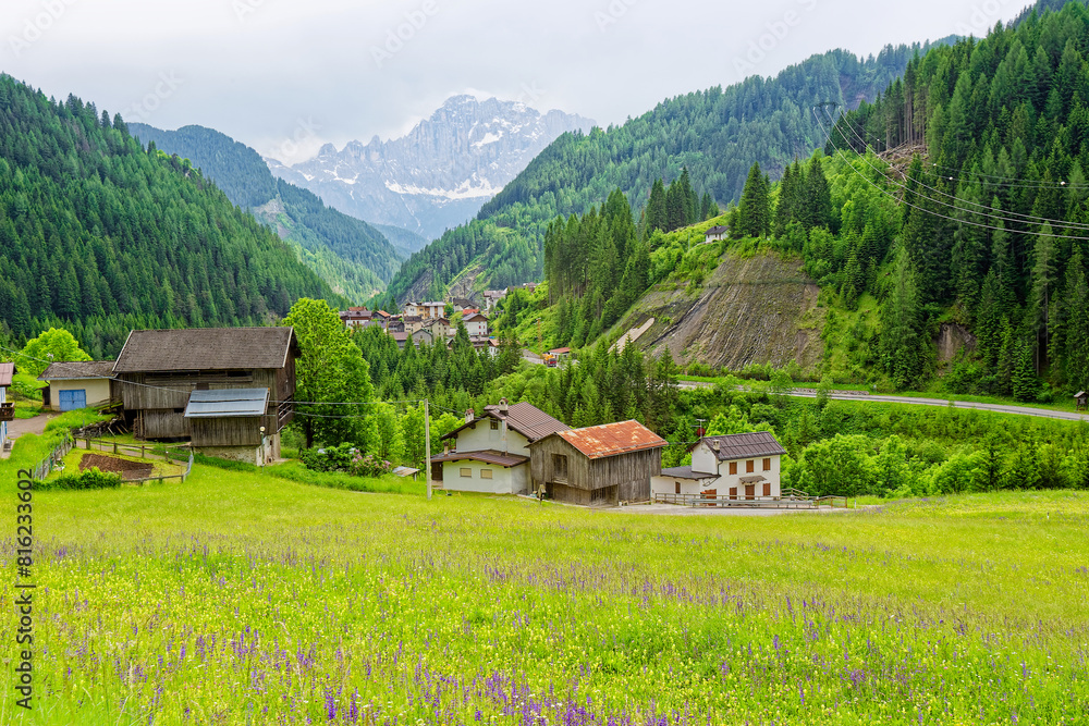 Fototapeta premium Small rural village nestled in the Dolomite Mountains Italy.Green morning scene of countryside in Swiss Alps, Bernese italian in the canton of Bern, Switzerland, Europe. Alpine mountain pasture