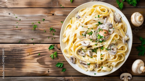 Creamy fettuccine pasta with mushrooms and parsley on a rustic wooden background.