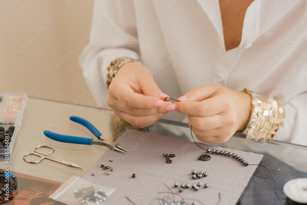 Obraz premium Artisan woman creates jewelry art hobby handcraft concept. The craftswoman creates jewelry