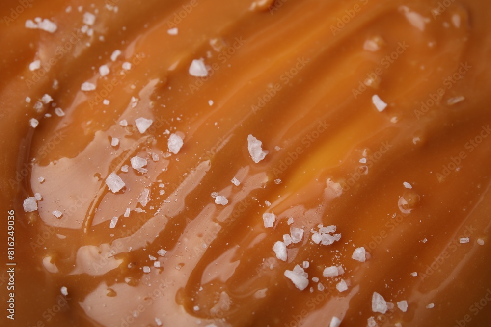 Delicious caramel sauce with sea salt as background, closeup Delicious caramel sauce with sea salt as background, closeup