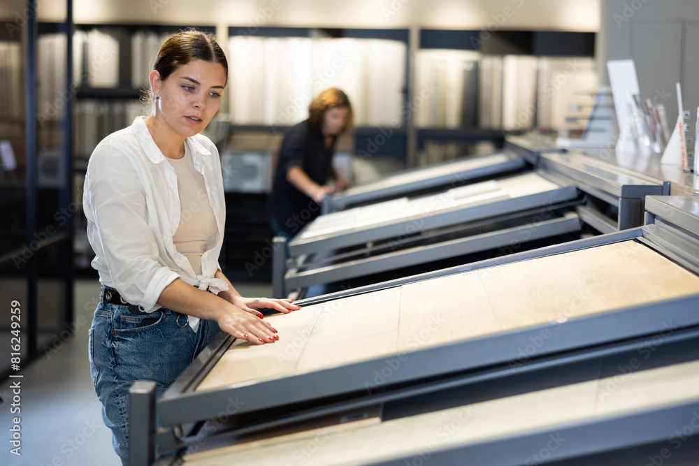 Obraz premium Female customer choosing kitchen ceramic tile in store