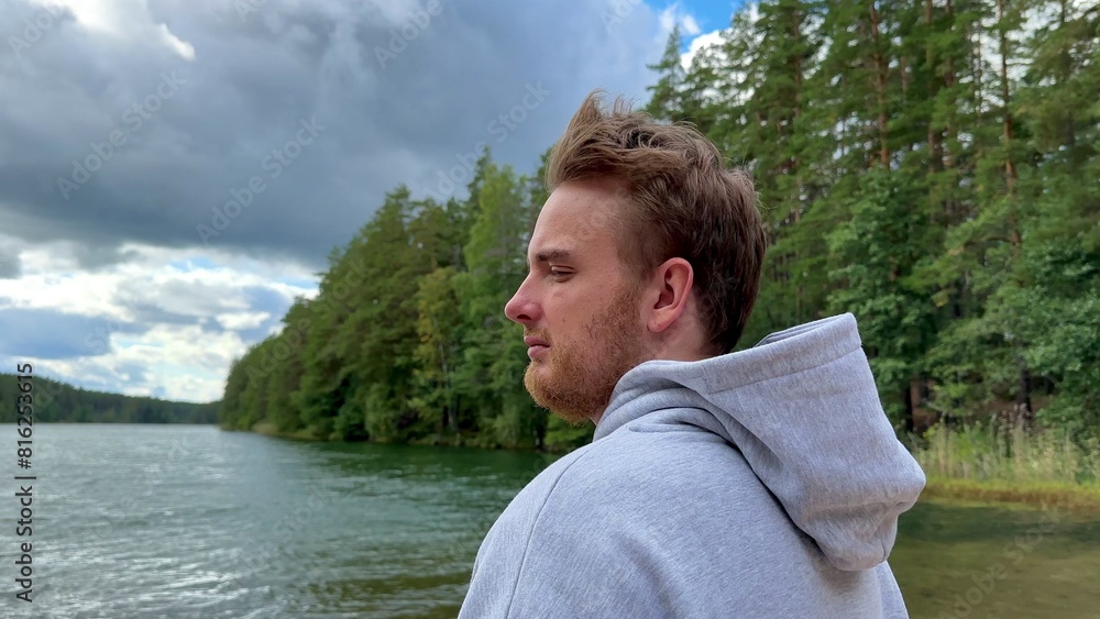 handsome man stands against of the lake and relax and breath handsome man stands against of the lake and relax and breath