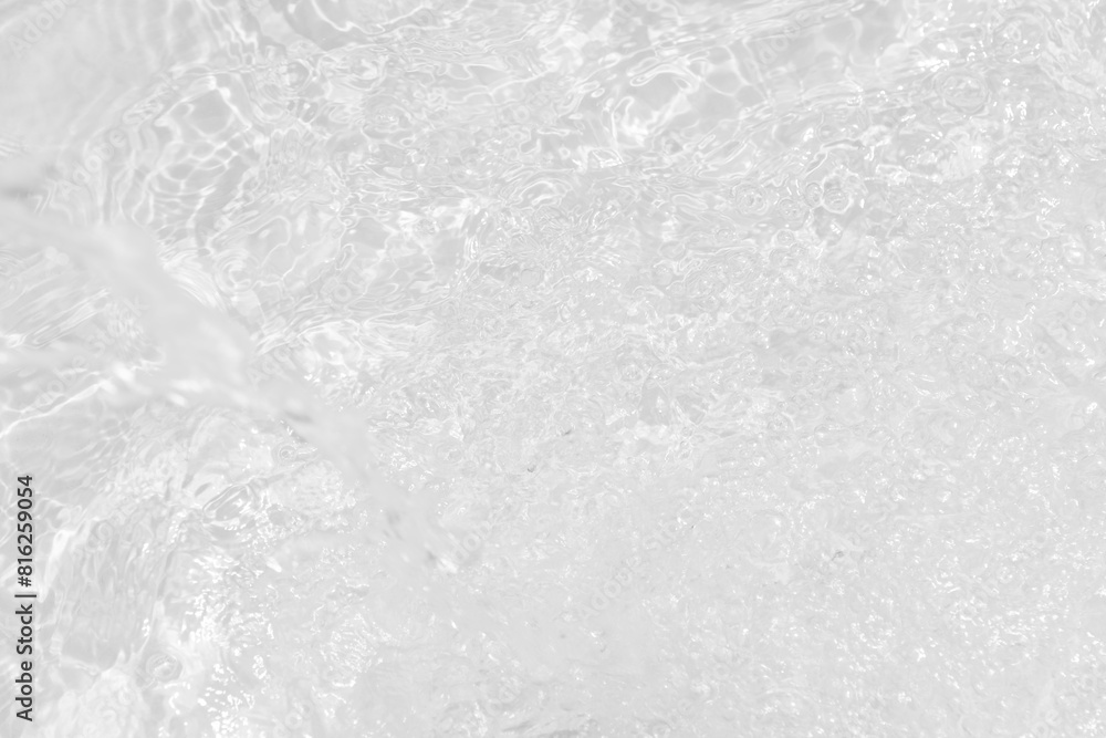 Obraz premium White water with ripples on the surface. Defocus blurred transparent white colored clear calm water surface texture with splashes and bubbles. Water waves with shining pattern texture background.
