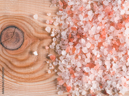 Himalayan pink salt in crystals on wooden background. Copy space