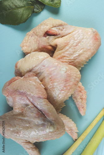 Uncooked or raw chicken wings on cutting board with ingredients.