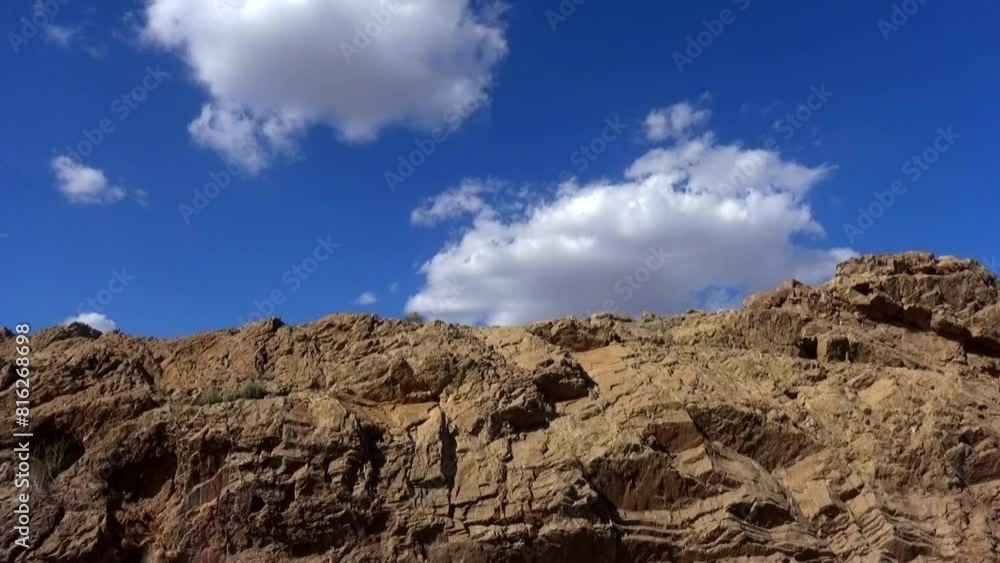 a mountain landscape, with a focus on a cluster of giant rocks set against the backdrop of majestic mountains as green bushes. a mountain landscape, with a focus on a cluster of giant rocks set against the backdrop of majestic mountains as green bushes.