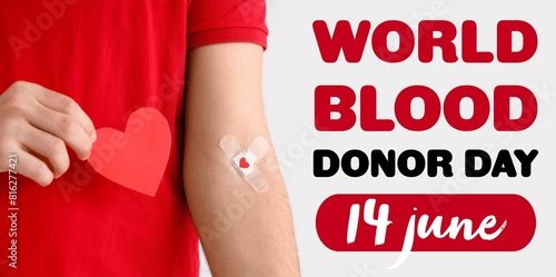 Young donor with applied medical patches and paper heart on light background, closeup. Banner for World Blood Donor Day photo