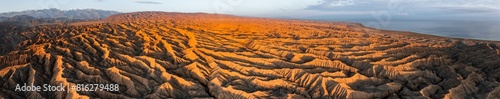 Panorama, landscape of eroded hills, badlands at sunset, Lake Issyk Kul in the background, aerial view, Canyon of the Forgotten Rivers, Issyk Kul, Kyrgyzstan, Asia photo