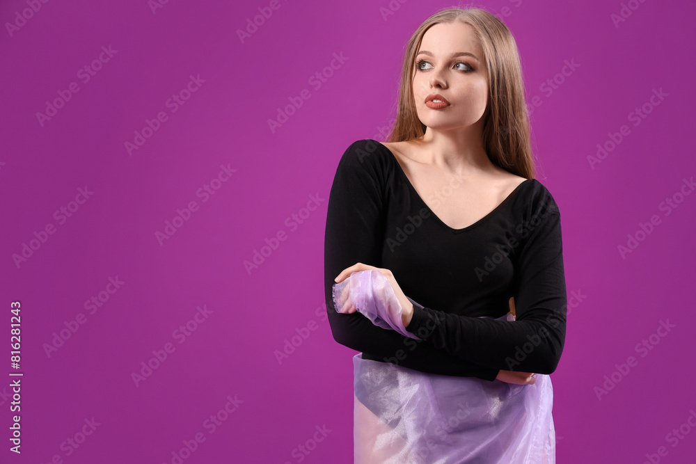 Beautiful young woman in bodysuit with fabric on purple background Beautiful young woman in bodysuit with fabric on purple background