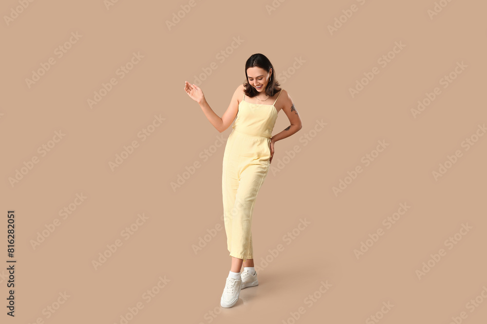 Beautiful young woman in stylish white sneakers on beige background Beautiful young woman in stylish white sneakers on beige background