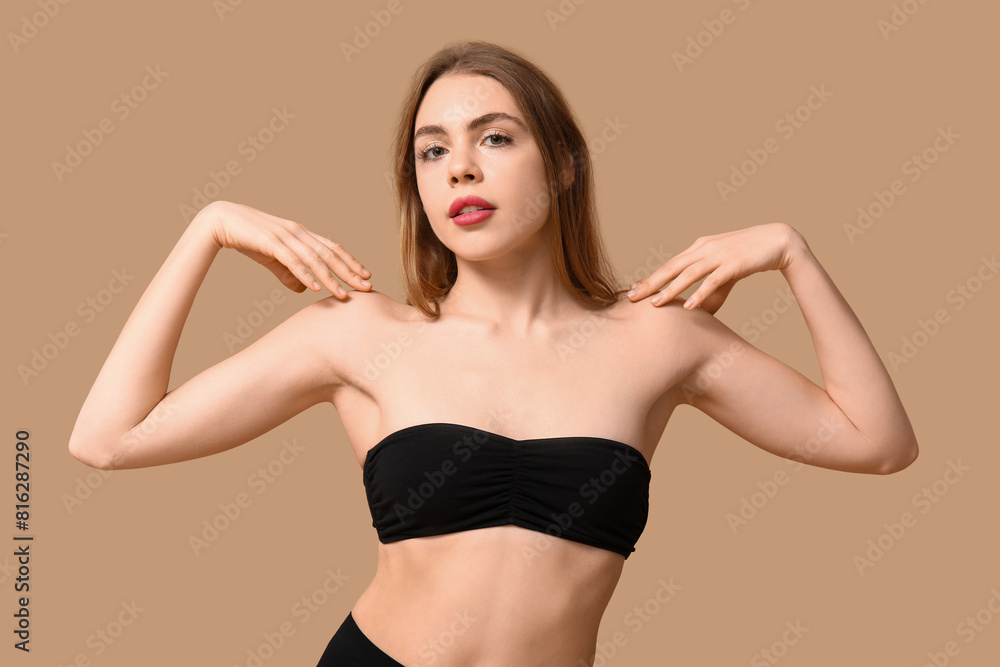 Attractive young woman in black underwear on beige background Attractive young woman in black underwear on beige background