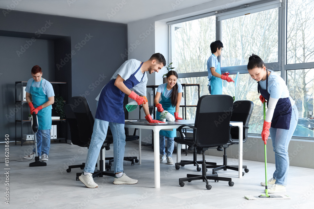 Team of young janitors cleaning in office Team of young janitors cleaning in office