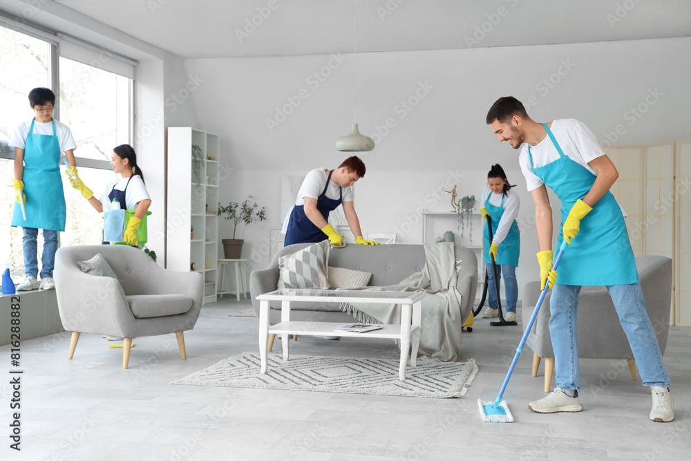 Team of young janitors cleaning in room Team of young janitors cleaning in room