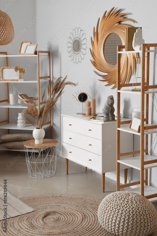 Fototapeta premium Interior of stylish living room with golden mirror and commode
