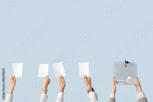 Hands holding ballot box and voting papers on light background. Election concept photo