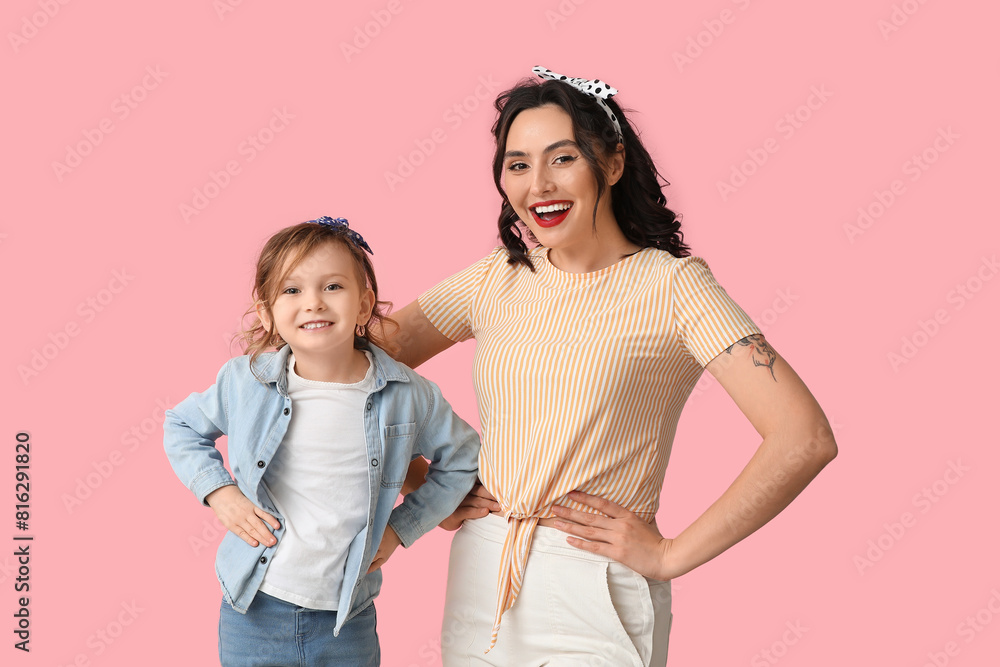 Happy pin-up woman and her daughter on pink background Happy pin-up woman and her daughter on pink background