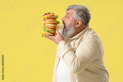 Overweight mature man eatin...