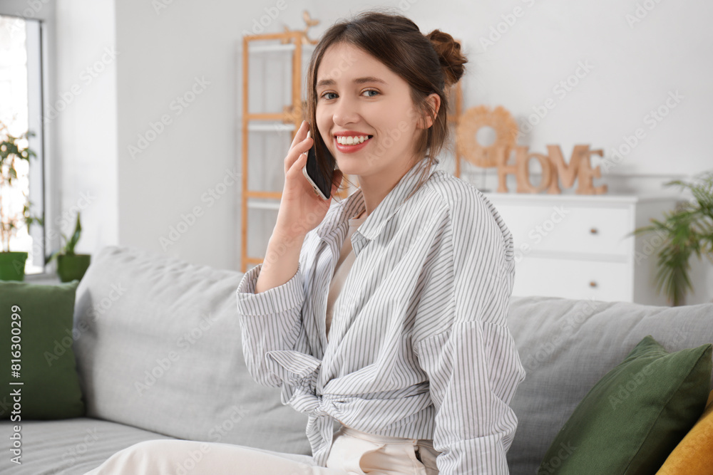 Beautiful young woman talking on phone in living room Beautiful young woman talking on phone in living room