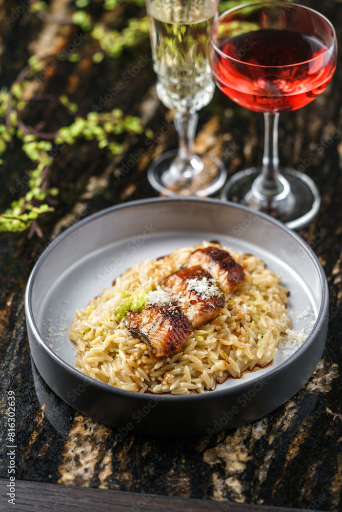 Delicious grilled fillet fish with rice, cheese and sauce in plate on marble background with drinks. Seafood, close up, top view Delicious grilled fillet fish with rice, cheese and sauce in plate on marble background with drinks. Seafood, close up, top view