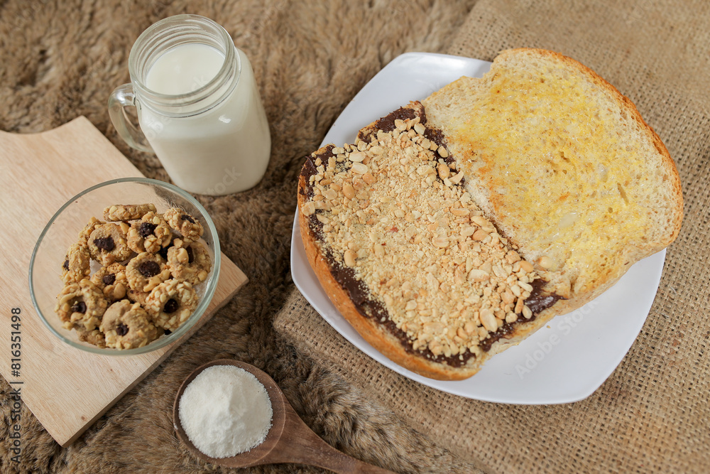Bread with peanut, chocolate and butter spread on a table for breakfast
Bread with peanut, chocolate and butter spread on a table for breakfast