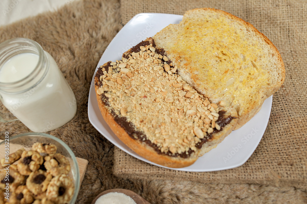 Bread with peanut, chocolate and butter spread on a table for breakfast
Bread with peanut, chocolate and butter spread on a table for breakfast