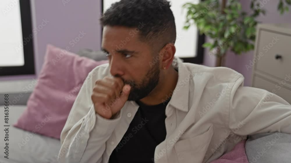 A thoughtful man coughs in a cozy bedroom, evoking a feeling of illness and contemplation indoors. A thoughtful man coughs in a cozy bedroom, evoking a feeling of illness and contemplation indoors.