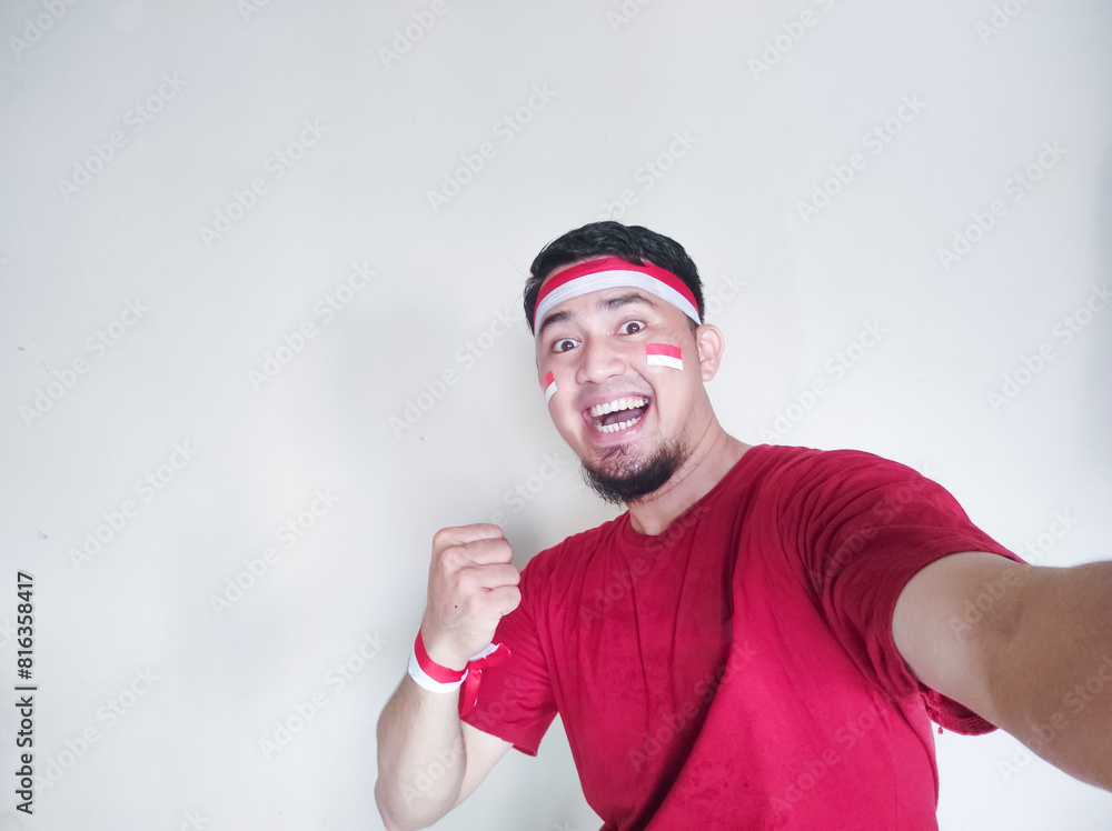 Indonesian man clenches fist with excited and happy expression on independence day Indonesian man clenches fist with excited and happy expression on independence day