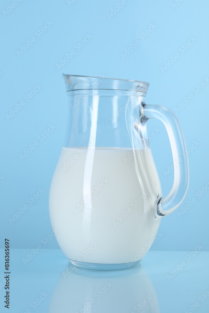 Jug of fresh milk on light blue background Jug of fresh milk on light blue background