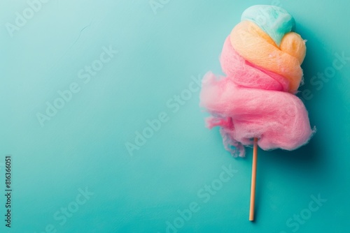 Multicolored cotton candy on a stick on blue background