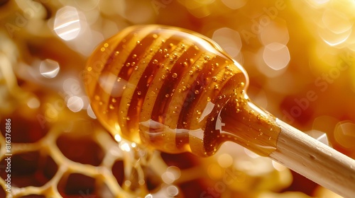 Honey dripping from the wooden honey dropper over thick golden honeycomb on a blurred background. A close up view of the natural organic sweet product. photo