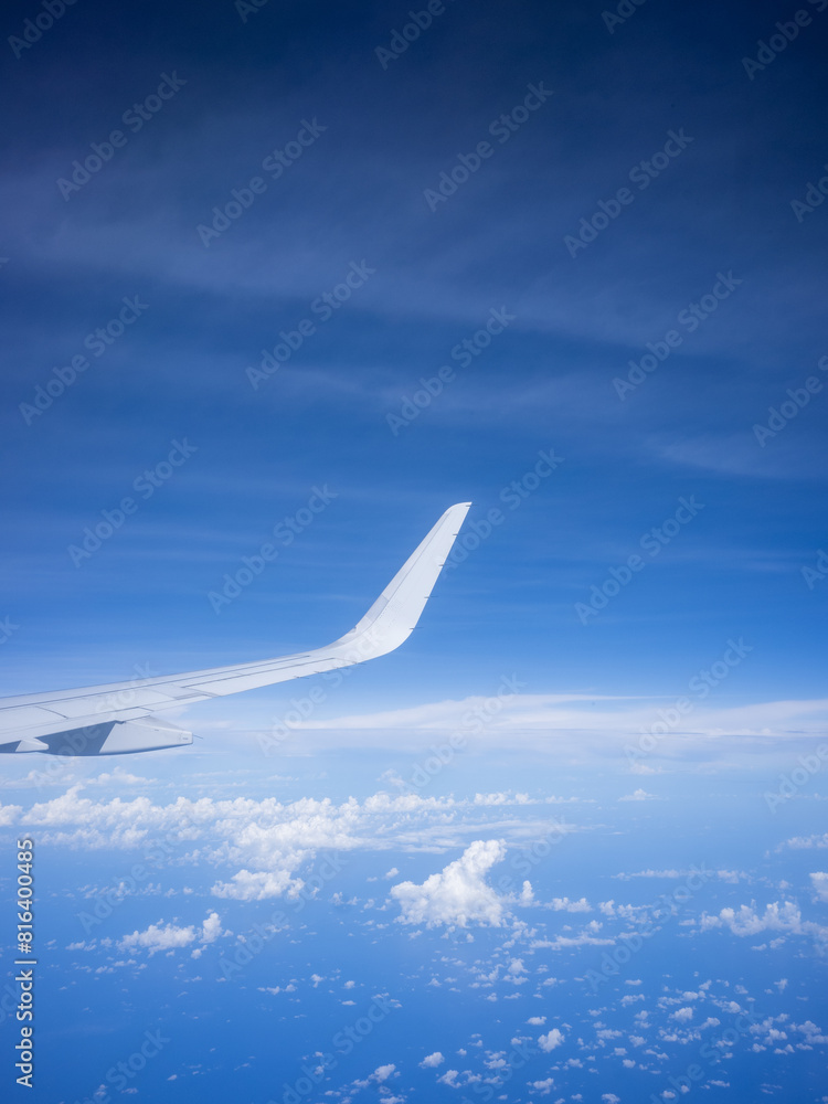 a wing of airplane and blue sky seen from the window of the seat a wing of airplane and blue sky seen from the window of the seat