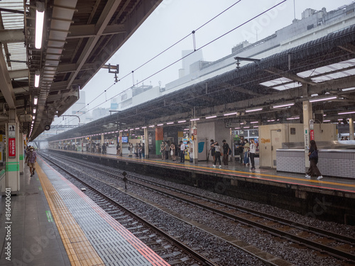 Photography many passengers waiting for the train coming at the platform in rainy day in tok