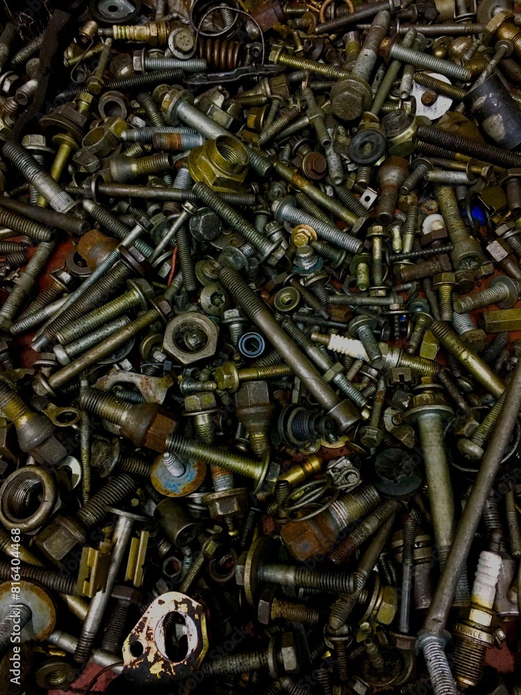 Picture of a pile of used screws of various sizes and types on a workshop floor Picture of a pile of used screws of various sizes and types on a workshop floor