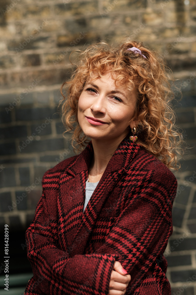 Classic portrait of smiling curly woman outdoors. Classic portrait of smiling curly woman outdoors.