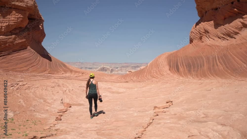 Lonely Woman With Photo Camera Walking Under Washed Sandstone Formations in Grand Canyon National Park, Arizona USA Lonely Woman With Photo Camera Walking Under Washed Sandstone Formations in Grand Canyon National Park, Arizona USA