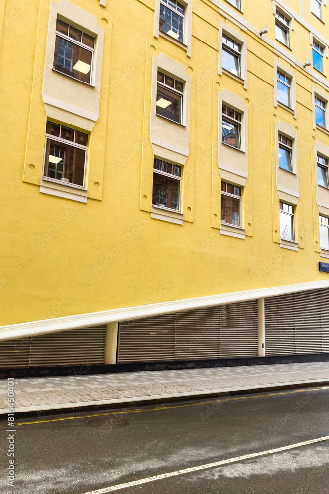 Bright yellow facade of a modern building. Geometry in an urban environment. Bright yellow facade of a modern building. Geometry in an urban environment.