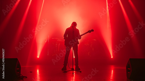 The silhouette of a musician standing on stage surrounded by bright red strobe lights bathed in the glow of stage lights Musician with guitar : Generative AI