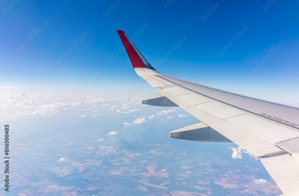 View from the airplane window at a beautiful cloudy sky and the airplane wing View from the airplane window at a beautiful cloudy sky and the airplane wing