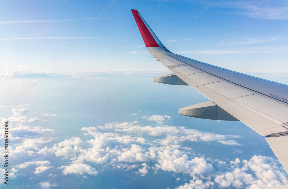 View from the airplane window at a beautiful cloudy sky and the airplane wing
