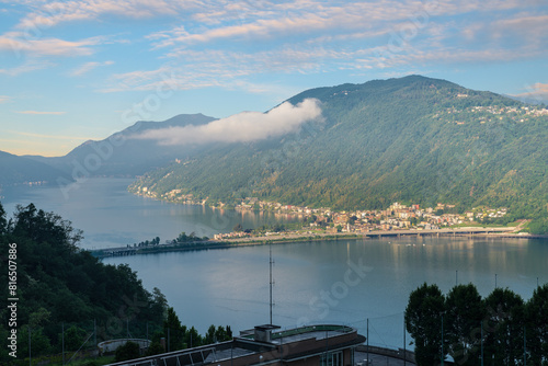 Lake Lugano in summer at sunrise. Aerial view of the town of Melide, Switzerland. Panorama towards Morcote and Porto Ceresio in Italy