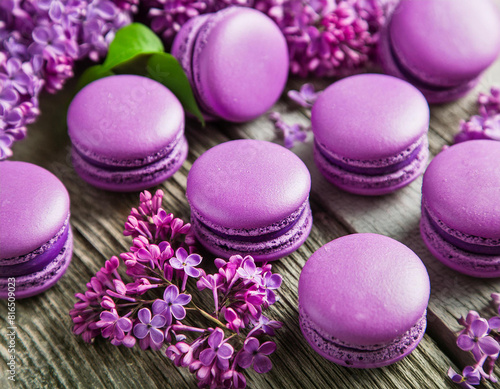 Sweet purple macarons or macaroons and Lilac or syringa vulgaris flowers on wooden table