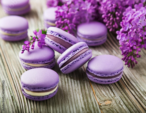 Sweet purple macarons or macaroons and Lilac or syringa vulgaris flowers on wooden table