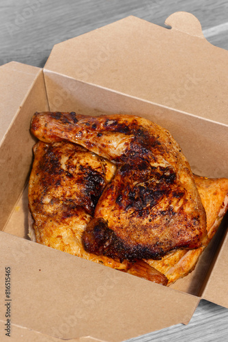 Piri Piri chicken, Coated in a hot spicy marinade, in a cardboard takeaway carton. Eco environmentally plastic free packaging concept