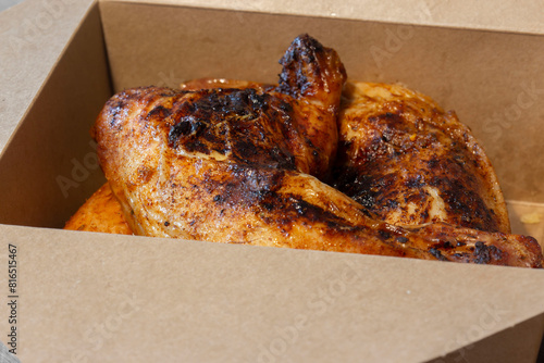 Piri Piri chicken, Coated in a hot spicy marinade, in a cardboard takeaway carton. Eco environmentally plastic free packaging concept